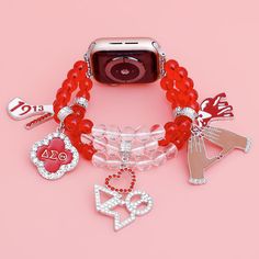 Delta Sigma Theta Sorority Paraphernalia Women's Watch Band. Silver Metal with 3 Rows of Red and Clear Acrylic Ball Beads Stretch Strands Featuring 5 Different Rhinestone Red and White DST Sorority Charms. Fits 38. 40. 41 mm. Easy Adjustable Sizing. Band measures 1" wide. Heart DST Charm measures 1". Sorority Paraphernalia, Delta Sigma Theta Gifts, Greek Paraphernalia, Beaded Watches, Theta Sorority, Delta Sigma Theta Sorority, Delta Sigma Theta, Women's Watch, Sorority