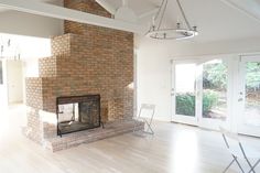 an empty living room with a brick fireplace