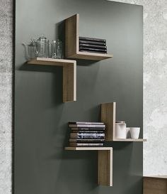 three wooden shelves with books and cups on them