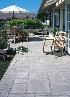 a patio with chairs and an umbrella on it