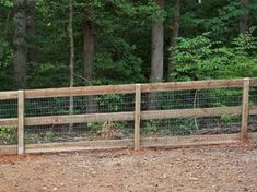 a wooden fence in front of some trees