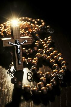 a rosary with a crucifix in the middle and light shining on it