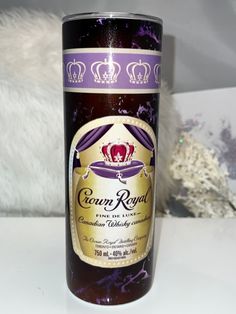 a bottle of crown royal wine sitting on a table next to a white teddy bear