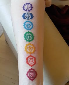 a person's arm with seven chakras on it