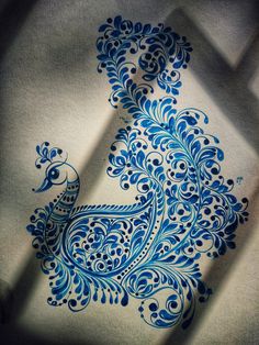 a blue and white peacock drawn on top of a piece of paper