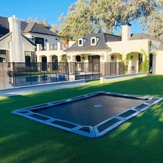 an inflatable trampoline is placed on the grass near a large house