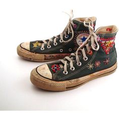 an old pair of black converse sneakers with colorful embroidered designs on them, side by side