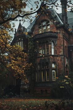 an old brick house surrounded by trees and leaves