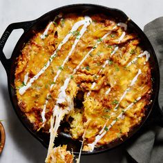 a casserole dish with cheese and sauce being lifted from the skillet by a spatula