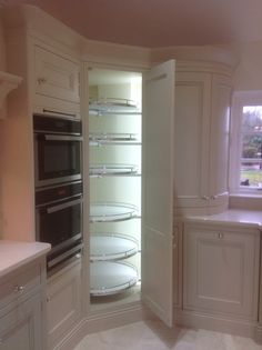 an empty kitchen with two ovens in the corner, and no one is inside