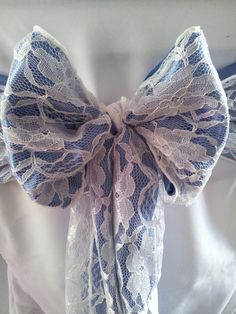 a blue and white bow tie on top of a table cloth with lace around it