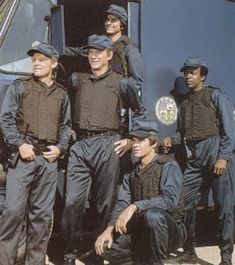 the men are posing in front of an airplane