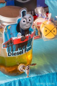 a thomas the tank engine themed drink in a jar on a table with other items