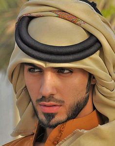 a man wearing a turban and looking at the camera with a serious look on his face