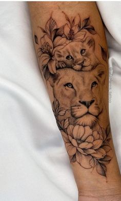 a woman's arm with a lion and flowers on it