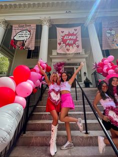 three girls in pink and white outfits posing on the steps with their hands up to the camera