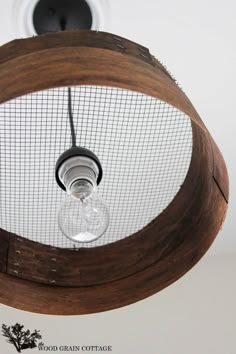 the light fixture is made out of wood and has a wire mesh covering it's bulb