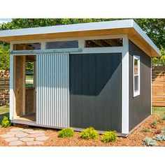 a gray and white shed sitting next to a wooden fence