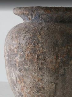 a close up of a vase on a white surface with no one around it or in the background