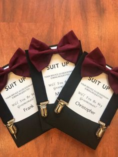 three pieces of black suspenders with red bow ties on wooden floor next to each other