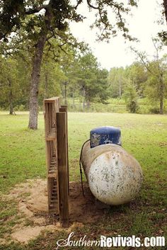 an old barrel sitting in the middle of a field