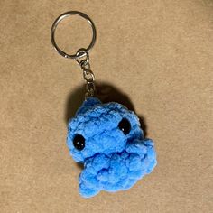 a blue stuffed animal keychain sitting on top of a table