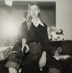 black and white photograph of a woman sitting on a couch with a cat next to her