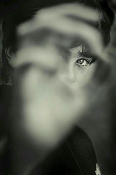 black and white photograph of a woman's face with her hands in the air