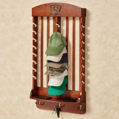 a hat rack with hats hanging from it's sides and on the wall, in front of a beige wall