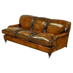 a brown leather couch sitting on top of a white floor