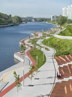 an empty walkway next to the water with people sitting on benches and walking along it