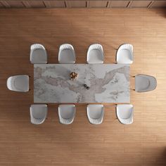 an overhead view of a dining room table with white chairs and marble topped centerpiece