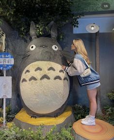 a woman standing next to a giant stuffed animal