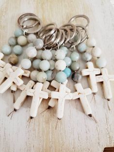 a bunch of beads that are sitting on a wooden table next to some metal rings