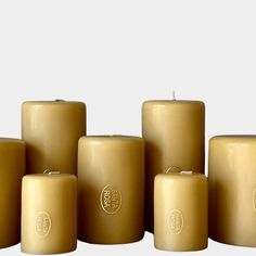 several candles are lined up on a white surface