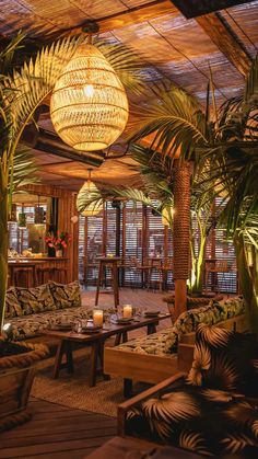 the inside of a restaurant with palm trees and couches