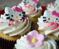 hello kitty cupcakes with white frosting and pink flowers