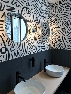 two white bowls are sitting on the counter in front of a black and white wall