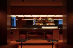 a dimly lit bar with stools in front of it