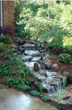 a small waterfall in the middle of a garden