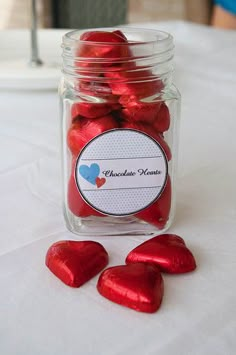 a jar filled with chocolate hearts sitting on top of a table