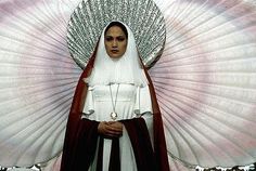 a nun standing in front of a giant fan