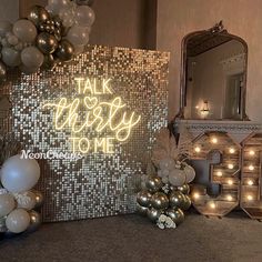 a table topped with balloons and lights next to a sign that says talk merry to me