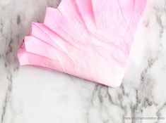 a piece of pink tissue sitting on top of a marble counter