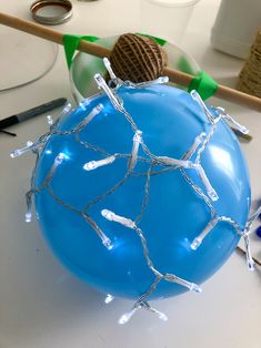 a blue balloon with lights on it sitting on top of a table next to other items