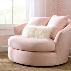 a pink chair with a fluffy pillow on it