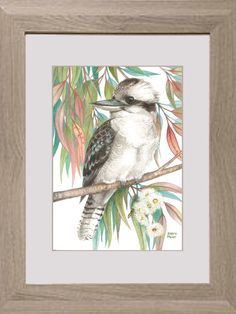 a bird sitting on top of a tree branch next to some leaves and flowers in a wooden frame