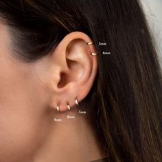 a woman's ear is shown with three different piercings on her left side