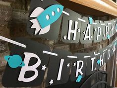 a birthday banner hanging from the side of a brick wall