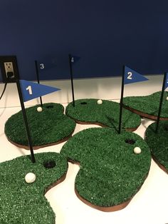 golf themed cookies are arranged in the shape of green grass with holes on each side